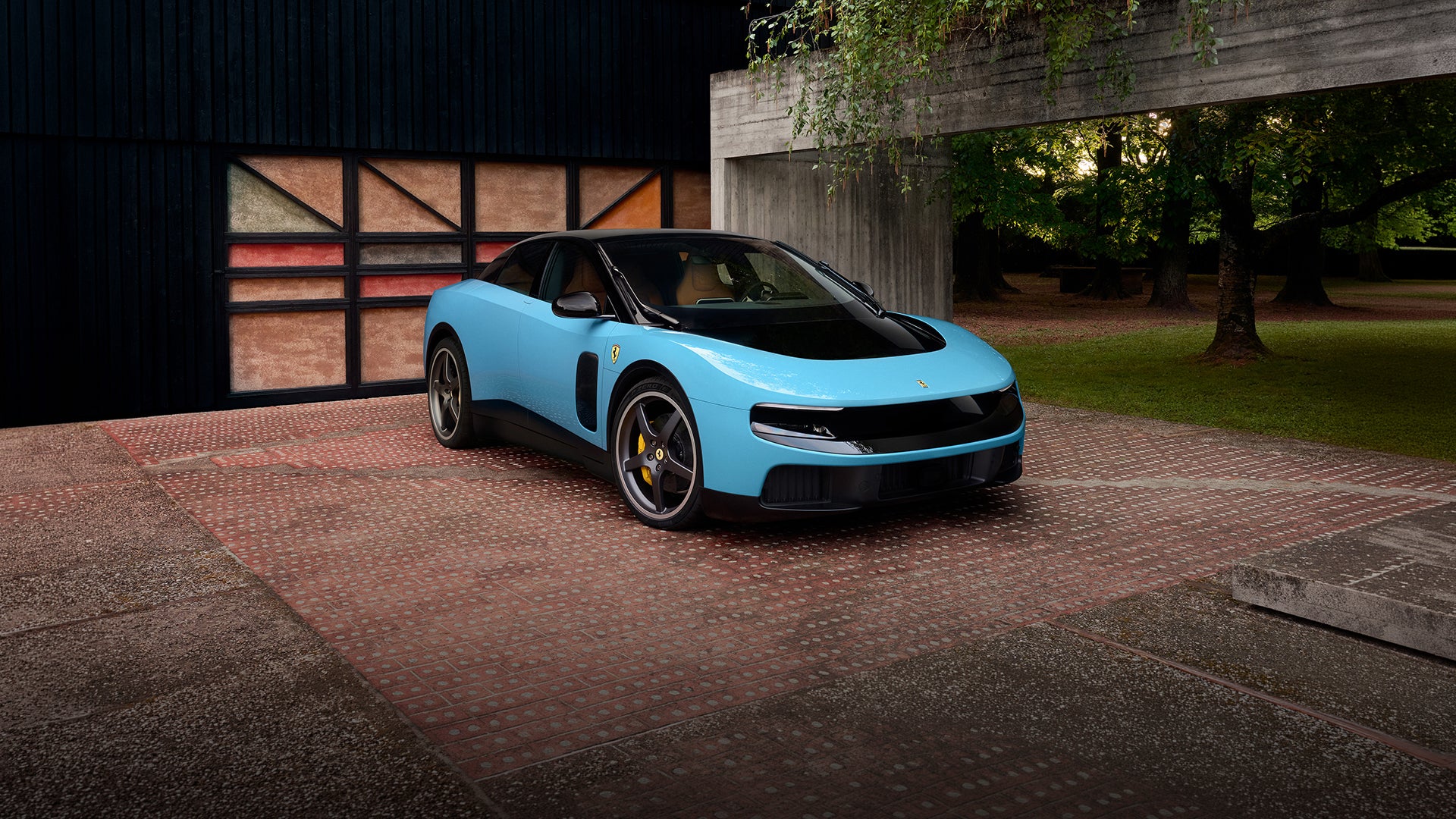 A bright blue sports car with a black roof and black trim sits on a red brick driveway in front of a modern building.