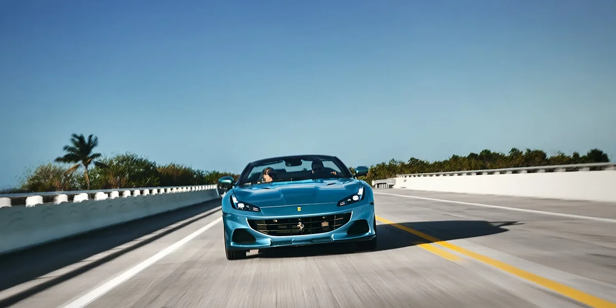 Ferrari Portofino M parked by the ocean with top down
