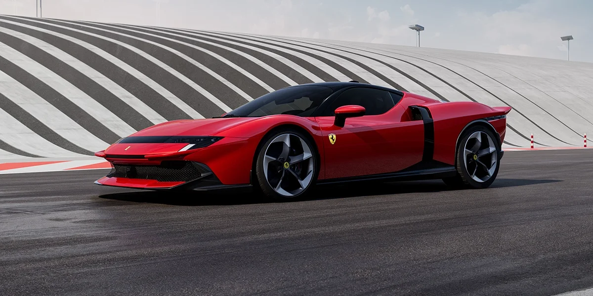 Front-side angle of the Ferrari 849 Testarossa in red on a race circuit, focusing on aerodynamics and sculpted bodywork.