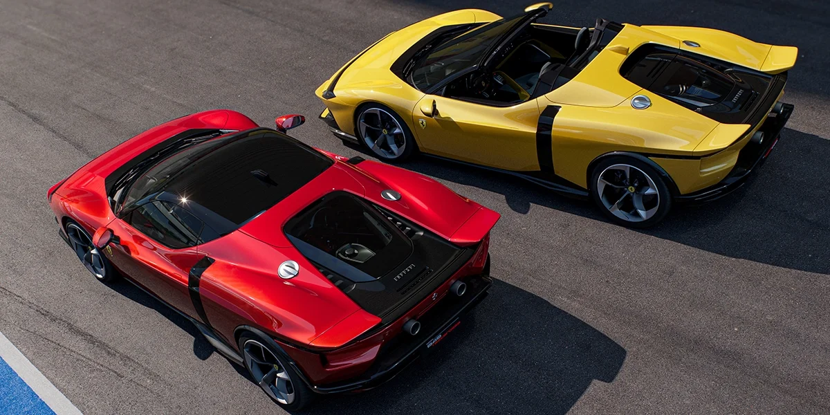 Top-down angle of two Ferrari 849 Testarossas, one in red and one in yellow, parked side by side on a track.